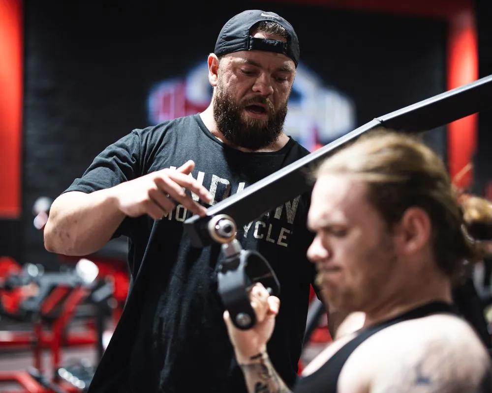 A trainer supporting a gym workout